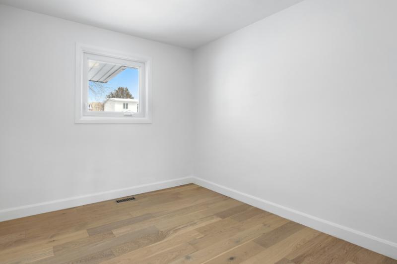 Sala vacía de paredes blancas y suelo de parquet